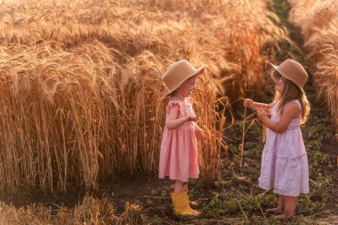 Hasır şapkalı ve pembe elbiseli iki kız kardeş buğday tarlasında koşuşturuyor. Kız arkadaşlar eğleniyor, çavdar viskisi topluyorlar. Sarı lastik çizmeli kız, diğeri çamurda yalınayak.