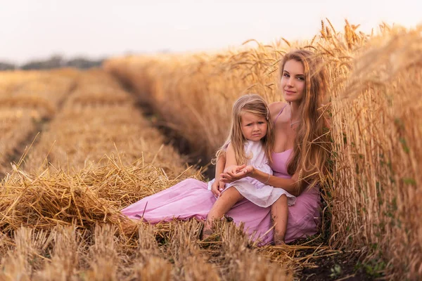 엄마와 황금빛 밀밭에 앉아서 재미를 있습니다 여자가 소녀를 즐겁게 간지럽힌다 — 스톡 사진