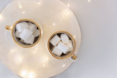 Beyaz bir seramik tepside, iki fincan şekerleme var, enerjik bir gilanda. Üst Manzara. İzole edilmiş beyaz bir arkaplanda. Tebrik kartı. Sıcaklık, rahat atmosfer. Boşluğu kopyala