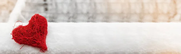 Een Spandoek Witte Sneeuw Een Rotan Rood Hart Tegen Achtergrond — Stockfoto