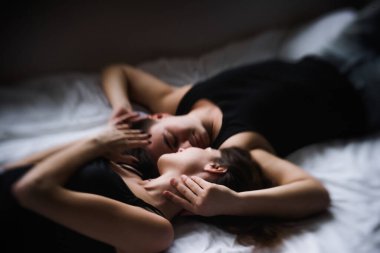 Birbirlerine aşık çiftler. Evdeki yatakta tepeden tırnağa uzanan Aşıkların yakın plan portresi. Yeni evlilerin sabahı, evde şenlikli bir tatil gününde şefkatle dinleniyorlar. Dokunulmazlık kavramı