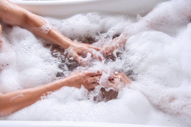 Birbirini seven bir çiftin beyaz köpükle banyo yaparken ki görüntülerini yakından izleyin. Aşıklar suyu sabunla sallayarak köpük oluşturur. Yeni evliler balayı hafta sonu sabahında eğlenirler. El hijyeni.