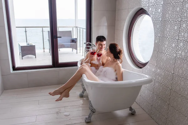 Młoda Szczęśliwa Para Zakochana Bierze Kąpiel Bąbelkami Widokiem Morze Pije — Zdjęcie stockowe