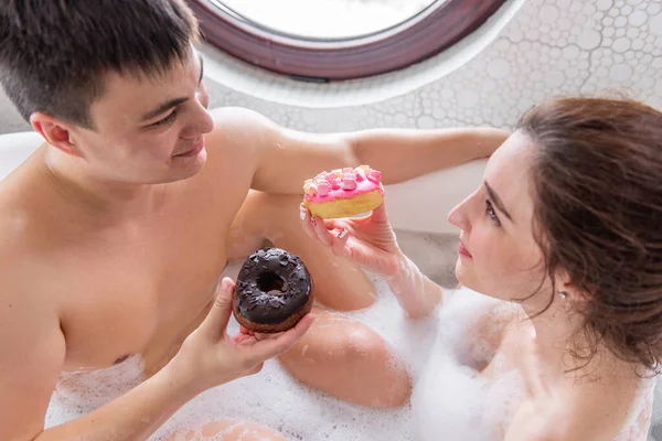 Una Pareja Enamorada Toma Baño Espuma Blanca Juntos Comen Rosquillas — Foto de Stock