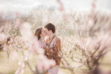 Gün batımında çiçek açan şeftali gül bahçelerinde aşık mutlu bir çift. Erkek genç bir kadının önünde duruyor, sarılıyor, şefkatle ve tutkuyla öpüyor. Romantik bir randevu, sevgililer balayı hafta sonu şehir dışında.
