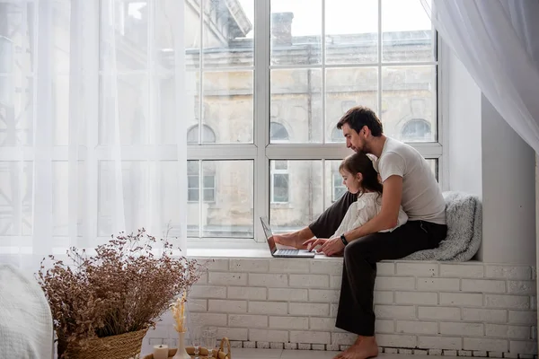 Baba Kız Pijamalarıyla Dizüstü Bilgisayarda Oynuyorlar Pencerenin Yanındaki Tahta Pencere — Stok fotoğraf