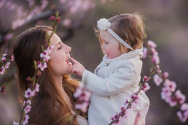Genç anne ve küçük kız çiçek açan gül bahçelerinde eğleniyorlar. Ağaçların arasında doğada oynayan, sarılan bir kızın portresi. Bekar anne baharda çocuğuyla yürür. Boşluğu kopyala