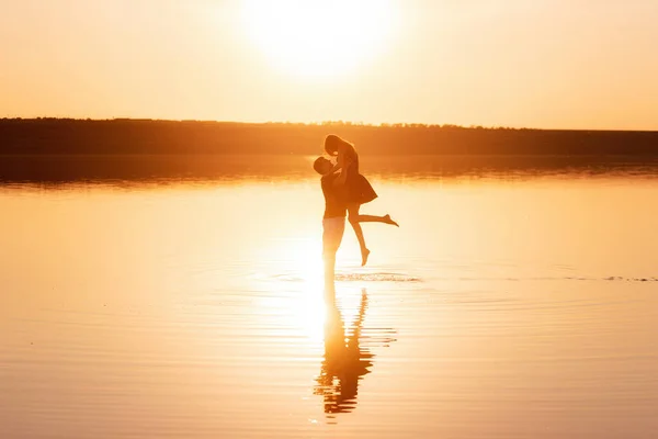 Birbirine Aşık Çiftlerin Silueti Portakal Rengi Günbatımında Gölün Sularında Sıçratarak — Stok fotoğraf
