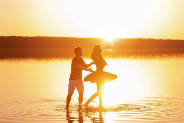 Silhouette Couple Love Dances Splashes Water Lake Rays Orange Sunset — стоковое фото