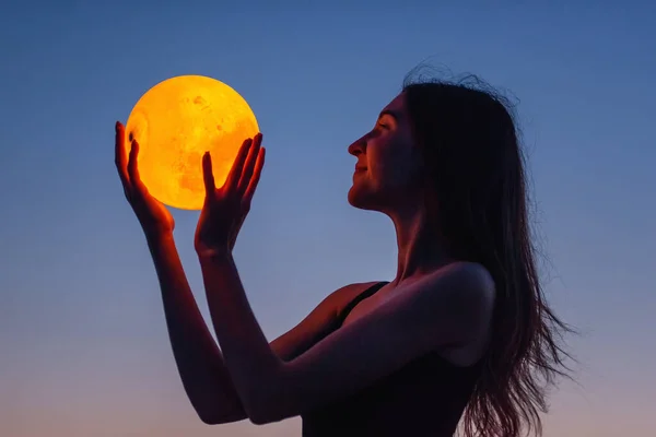 Young Woman Holds Full Moon Her Hands Backdrop Red Sunset — Stock fotografie