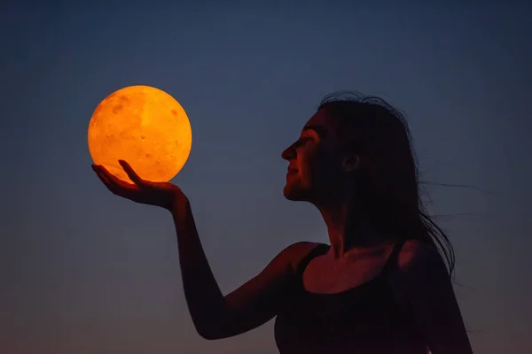 Young Woman Holds Full Moon Her Hands Backdrop Red Sunset — Foto Stock