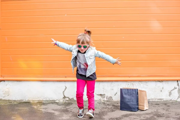 Little Stylish Girl Sunglasses Craft Bags Shopping Trip Orange Background — Stock Photo, Image