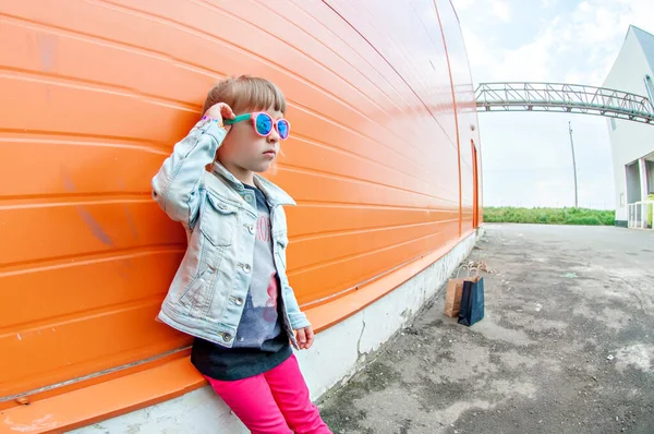 Little Stylish Girl Sunglasses Craft Bags Shopping Trip Orange Background — Φωτογραφία Αρχείου