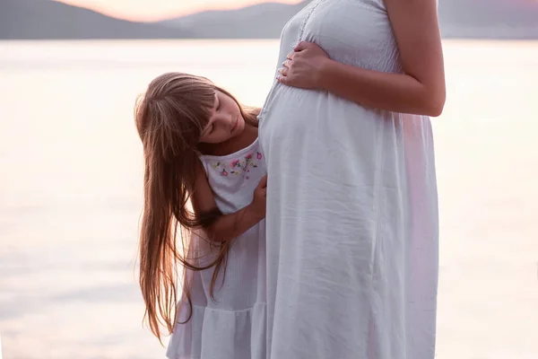 Close Portrait Little Girl Hugging Pregnant Mother Daughter White Sundress — ストック写真