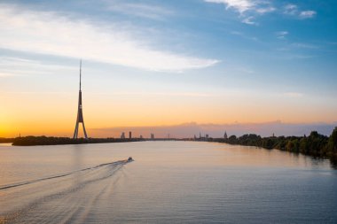 Riga eski kasaba panoraması ve TV kulesi. Daugava nehrinin üzerinde gün batımı