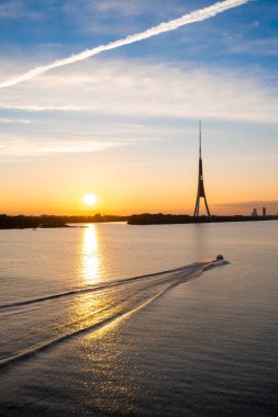 Daugava nehrinin üzerinde gün batımı. Riga eski kasaba panoraması ve TV kulesi