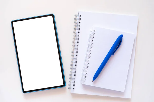 Planner, notebook and blue pen lie near teblet on light beige background — Stockfoto