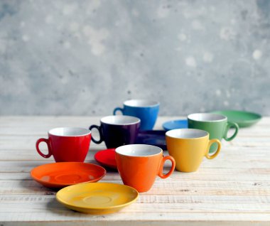 Beyaz ahşap arka planda parlak, çoklu sarmalanmış porselen çay fincanları..