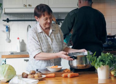 Sağlıklı ev yemekleri. Yaşlıların hayatı işte. Mutfakta bir emekli masaya konmuş malzemelerden çorba hazırlıyor. Bunlar doğal havuç, yeşillik, patates ve lahana. Ne yersen osun..