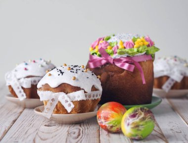 Ev yemeği. Kulichi, Paskalya bayramı için hafif ahşap arka planda, kurdelelerle süslenmiş geleneksel bir bayram pastasıdır..