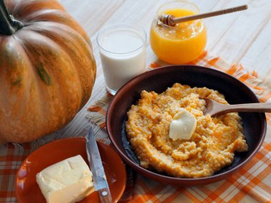 Kabak meyveli ahşap beyaz bir masaya balkabağı eklenmiş Millet lapası. Diyet yemek..