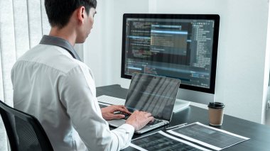 Bilişim ofisinde yazılım javascript bilgisayarı üzerinde çalışan genç programcı, problem çözümü bulmak için kodlar ve veri kodu web sitesi ve kodlama veritabanı teknolojileri yazıyor.