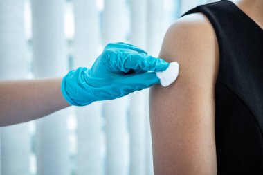 Doktor iğneyle hastaya aşı yapıyor. Grip aşısı için koluna bağışıklık aşısı yaptırıyor. Salgına karşı koronavirüs koruyucu..