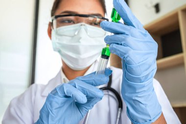 Laboratuvarda virüs ve aşı antiretroviral koronavirüs hakkında çalışan kadın araştırmacı ya da doktor test tüpleri ve mavi sıvı çözeltisi ile araştırma yapıyor..