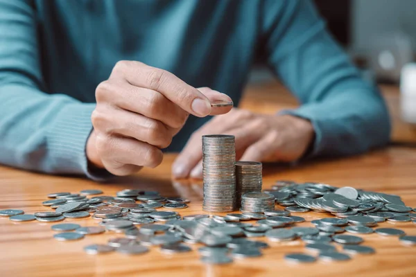 Genç adam ve yığınla madeni para gelecekte seyahat, eğitim, ev ve emeklilik için biriktirme stratejisi ve yığınla madeni para..