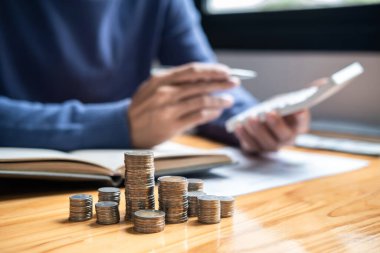 Madeni para yığını görüntüsü, genç adam ve gelecekte seyahat, eğitim, ev ve emeklilik planlama fonu için yığınla madeni para biriktirme stratejisi planlama için para yığını.