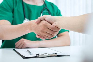 İyi iş birliği, doktor ve hasta hastanede iyi ve başarılı bir tedavinin ardından el sıkışıyor..
