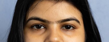 Tek kaşlı bir kadının yakın görüntüsü