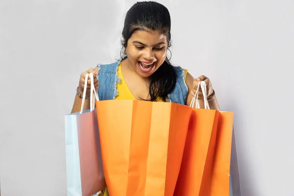 美しいインド人女性は白い背景にショッピングバッグを見て — ストック写真