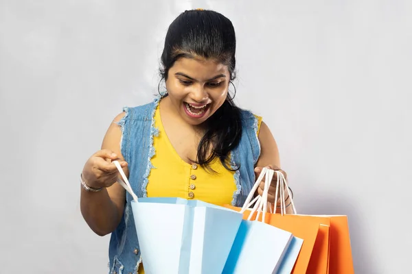 美しいインド人女性は白い背景にショッピングバッグを見て — ストック写真