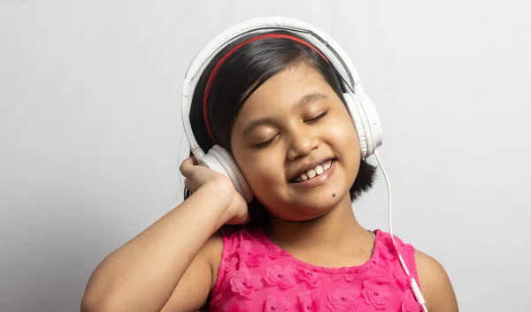 Słodkie Indyjskie Dziecko Dziewczyna Słuchanie Muzyki Dotykając Biały Słuchawki Białym — Zdjęcie stockowe