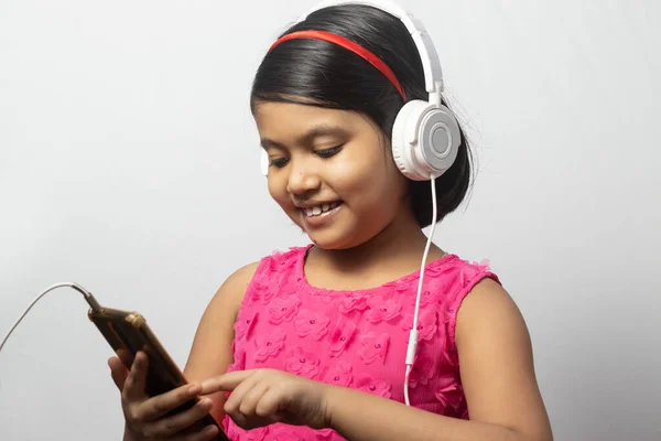 Słodkie Indyjskie Dziecko Dziewczyna Słuchanie Muzyki Smartfona Białym Słuchawką Białym — Zdjęcie stockowe