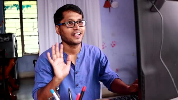 インド人男性で青いドレスビデオ通話と仕事上のコンピュータに自宅 — ストック動画