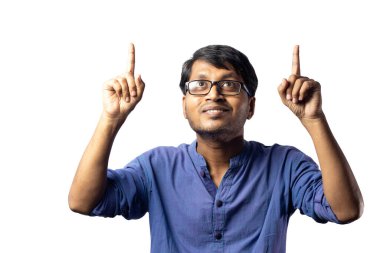 Mavi elbiseli genç bir Hintli beyaz arka planda iki işaret ile yukarıya bakıyor.