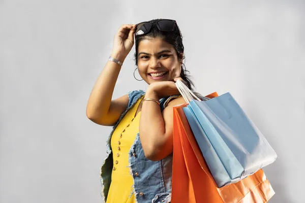 白い背景にショッピングバッグと大きな笑顔と黄色のドレスの美しいインド人女性 — ストック写真