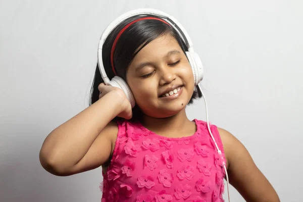 Słodkie Indyjskie Dziecko Dziewczyna Słuchanie Muzyki Dotykając Biały Słuchawki Białym — Zdjęcie stockowe