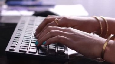Masaüstü bilgisayarının klavyesini yazan Hintli bir kadının ellerini kapat