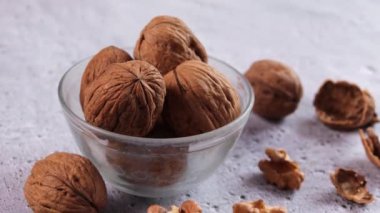 Bir kasedeki cevizlere ve beyaz arka plandaki çekirdeklere odaklan