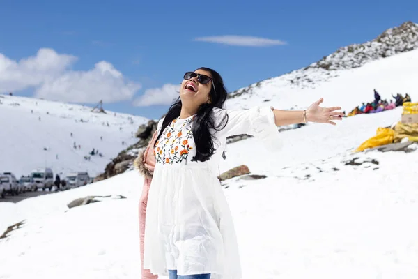 An Indian beautiful woman enjoying cold in snowy mountain