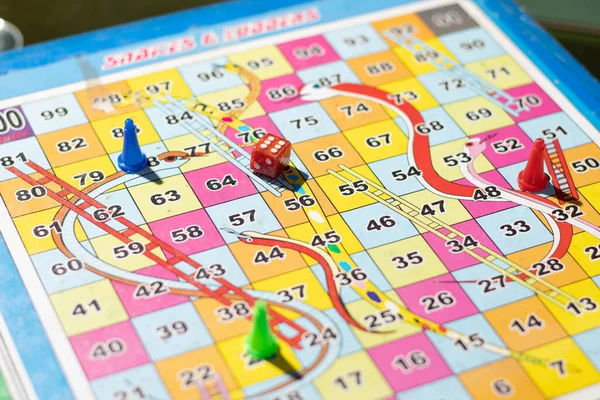 Selective focus on a dice in a snakes and ladders indoor board game