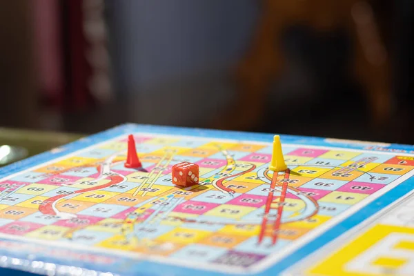 Selective focus on a dice in a snakes and ladders indoor board game