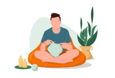 Genç bir adam oturur ve örgü iğneleriyle kalın elbiseler örer. Sıcak bir ev ortamında hobinin tadını çıkar. Düz biçimli vektör illüstrasyonu.