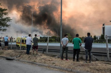 ATHENS, GREECE-03 AĞUSTOS 2021: Yetkililer tarafından kapatılmış olan ulusal otoyolun yakınındaki kontrolsüz bir şekilde orman yangınına müdahale ediyorlar. 