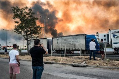 ATHENS, GREECE-03 AĞUSTOS 2021: Yetkililer tarafından kapatılmış olan ulusal otoyolun yakınındaki kontrolsüz bir şekilde orman yangınına müdahale ediyorlar. 