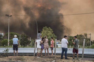 ATHENS, GREECE-03 AĞUSTOS 2021: Yetkililer tarafından kapatılmış olan ulusal otoyolun yakınındaki kontrolsüz bir şekilde orman yangınına müdahale ediyorlar. 