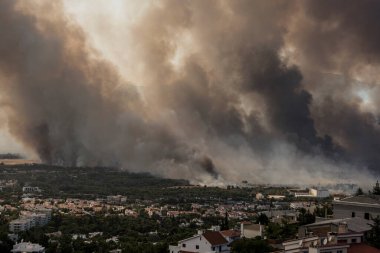 Atina, Yunanistan, 03 Ağustos 2021: Atina 'nın kuzeyindeki Varympompi banliyösünde büyük çaplı bir yangın görüldü. Kalın duman pirokümülüs fenomenini gösteriyor.. 